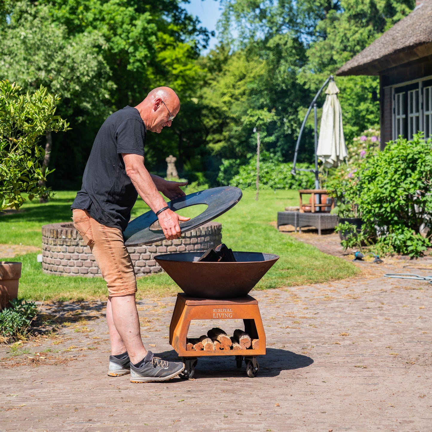 BBQ Plancha Grill Brasero Corten steel fire bowl with large wheels, wood storage and Cooking Plate Ø80cm