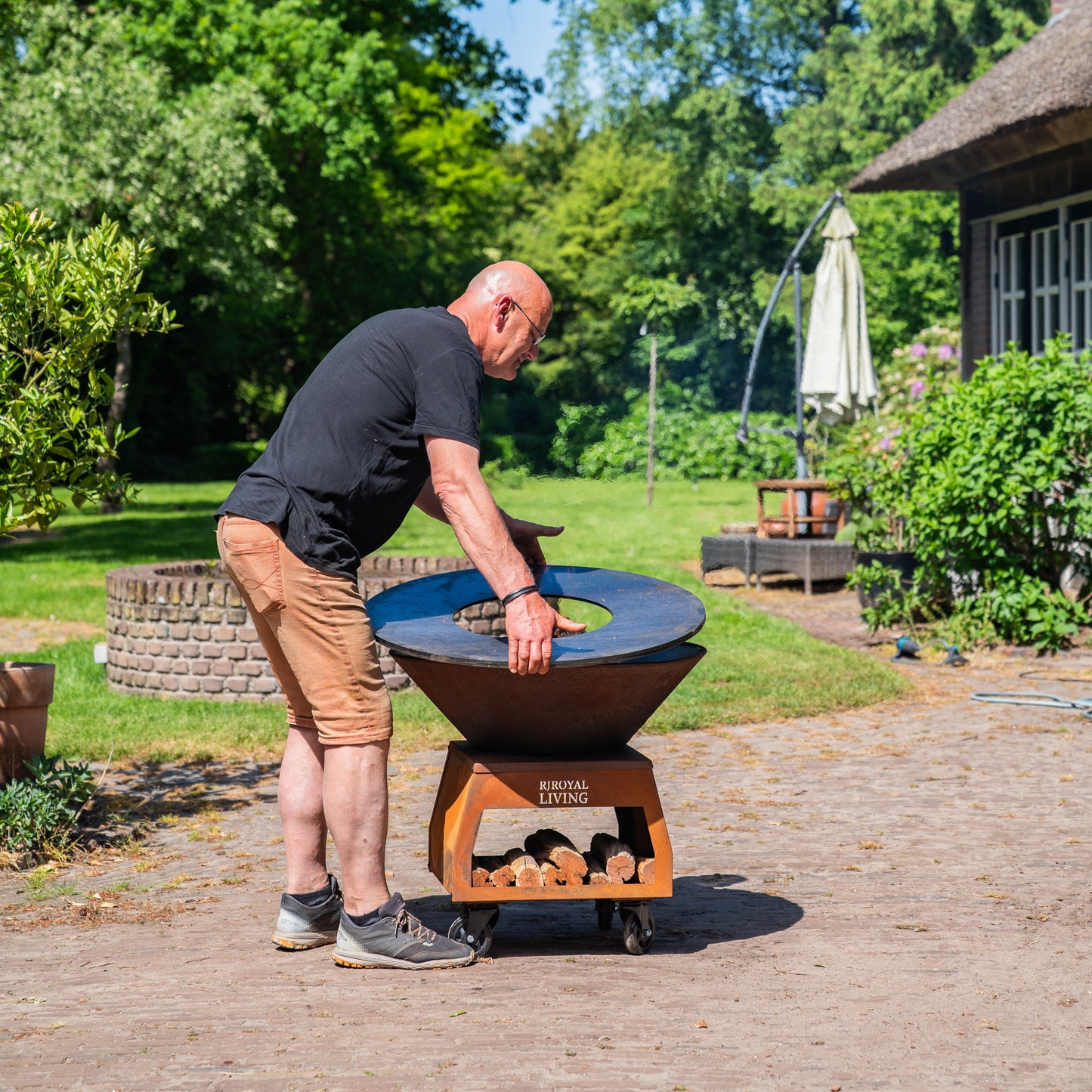 BBQ Plancha Grill Brasero Corten steel fire bowl with large wheels, wood storage and Cooking Plate Ø80cm