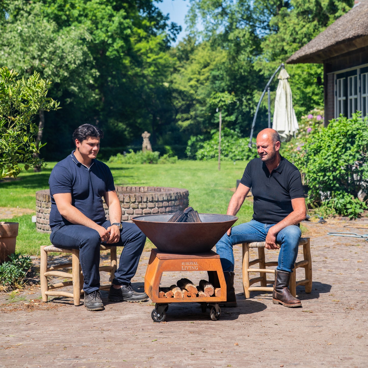 BBQ Plancha Grill Brasero Corten steel fire pit with large wheels and wood storage Ø75cm