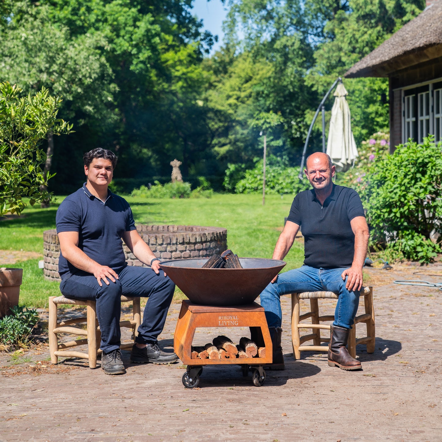 BBQ Plancha Grill Brasero Corten steel fire pit with large wheels and wood storage Ø75cm