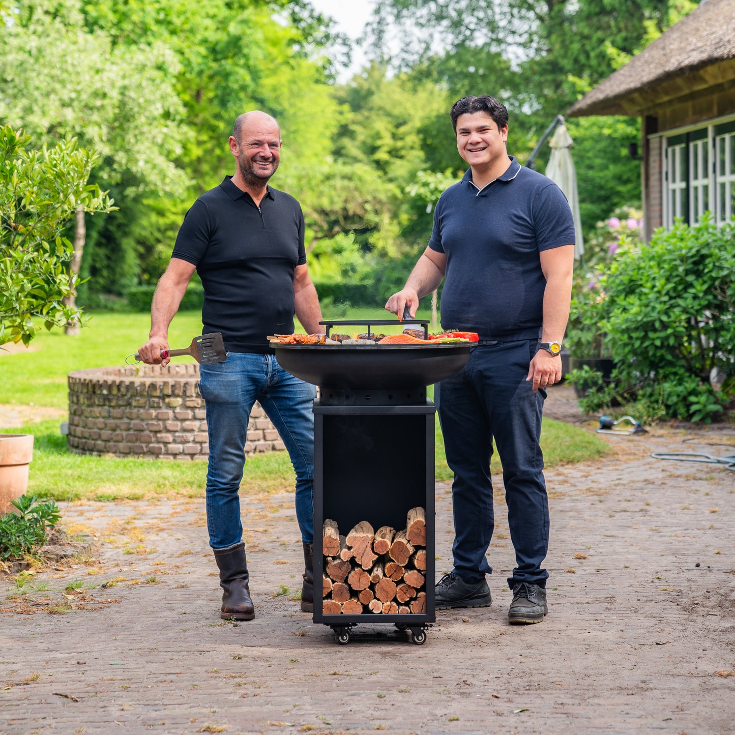 BBQ Plancha Grill Blackline 8mm Camarada 2.0 - With poker and wood storage Ø70cm